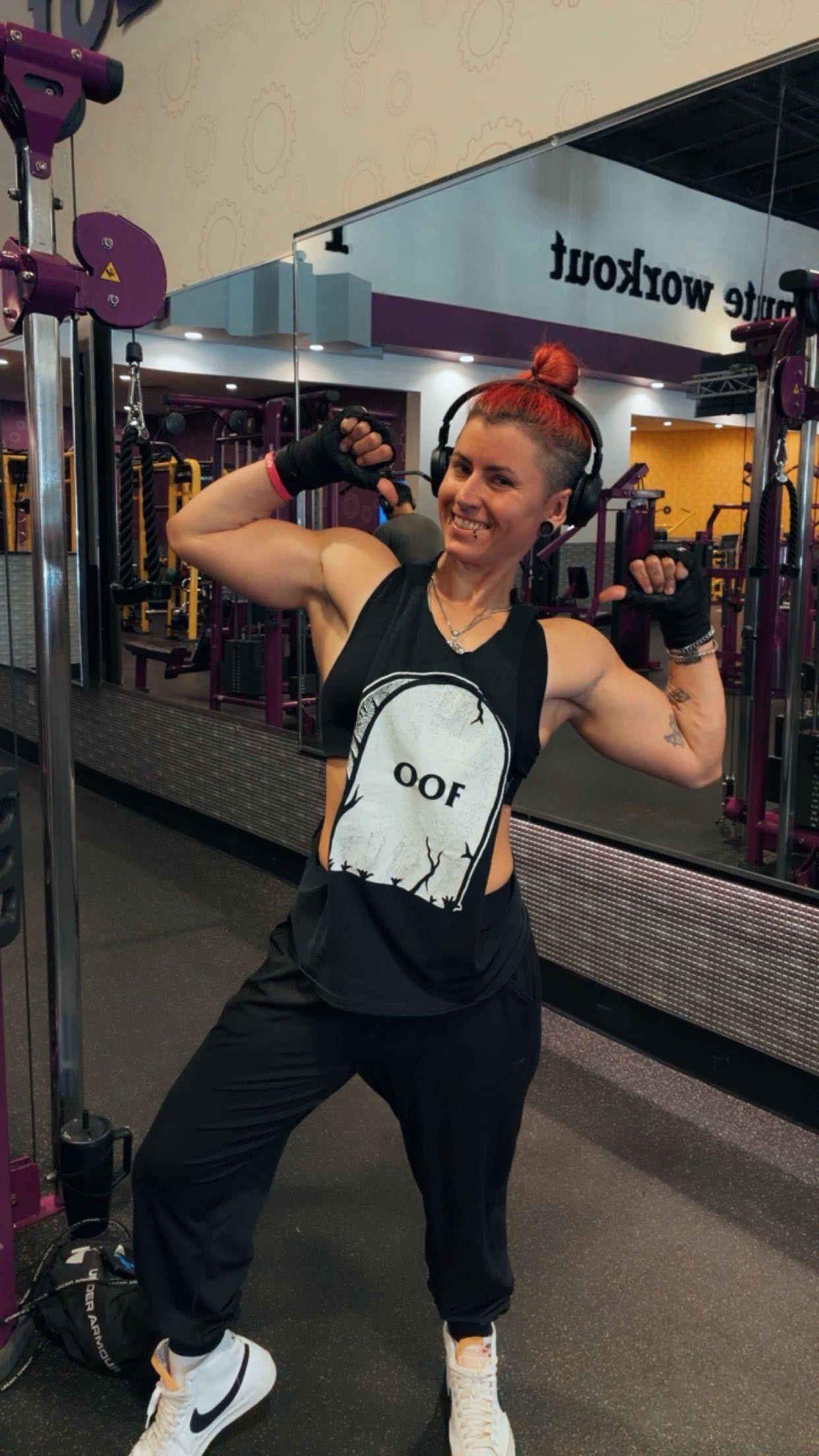 Brittney Sims, Level 4 Master Trainer and Advanced Nutrition Specialist in Cape Coral FL, flexing at Planet Fitness — Elite Mom Body Transformation coach